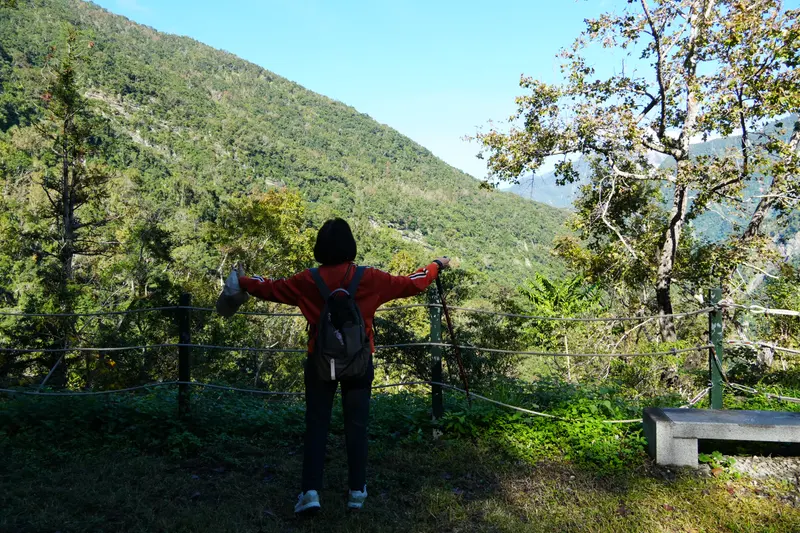 有人在觀景處張開雙臂看山