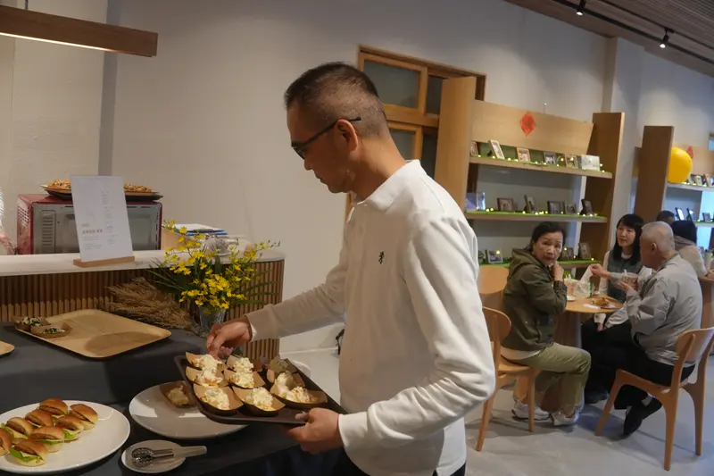有人在餐檯前取餐,後方坐著幾桌人