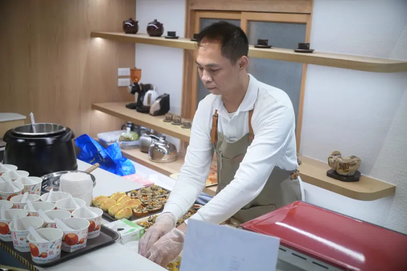 志工在流理臺前準備茶水