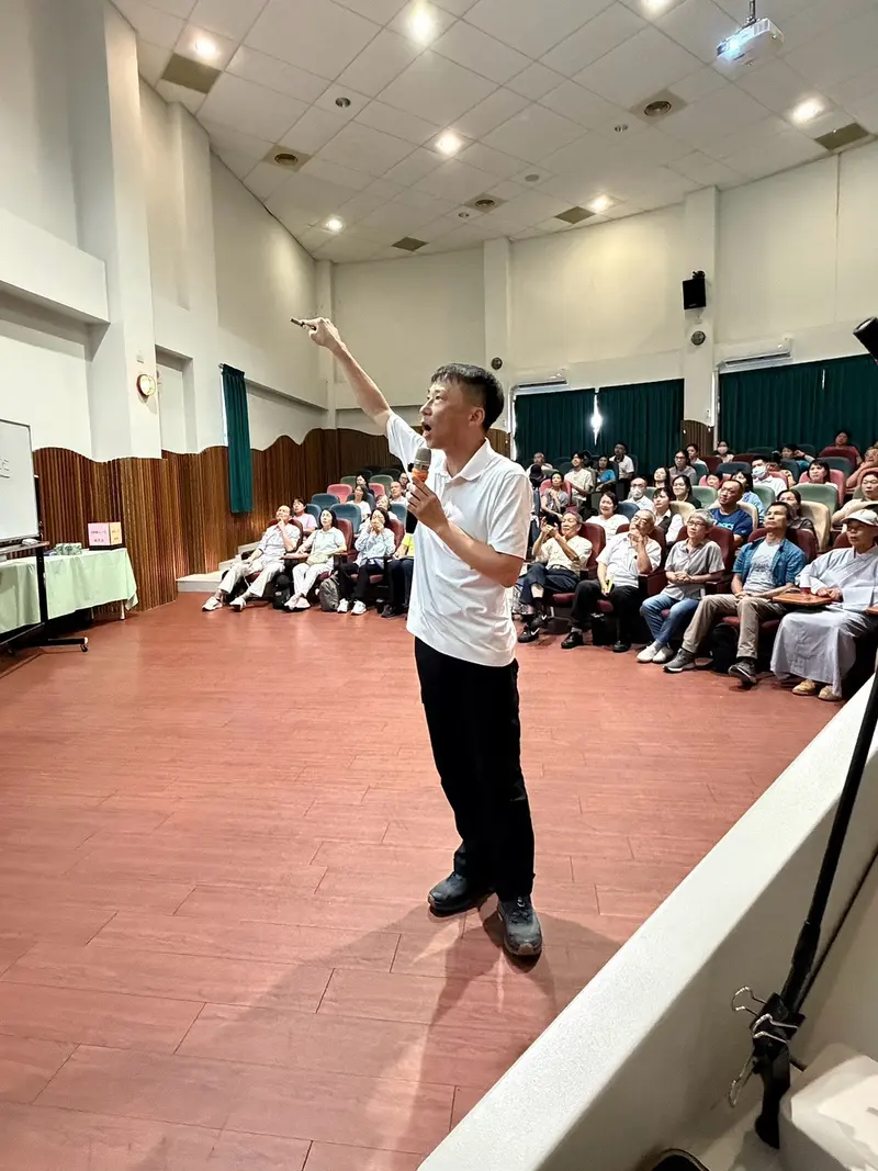 老師高舉手臂,對著滿場說話