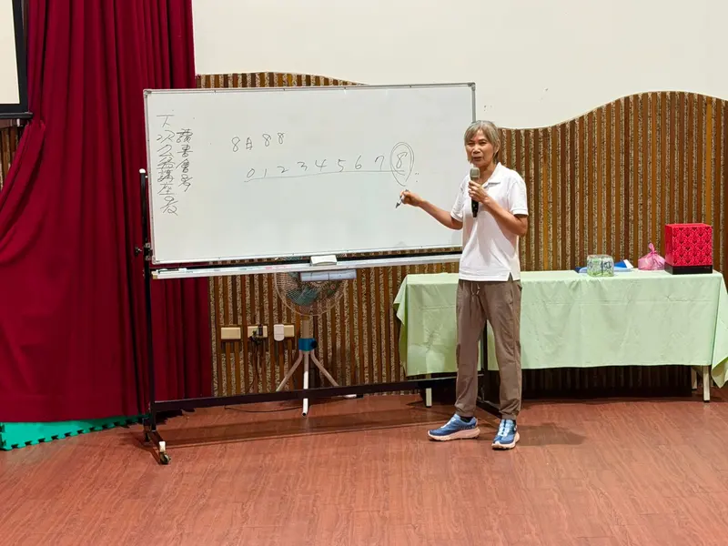 講者站在寫滿字的白板旁講解