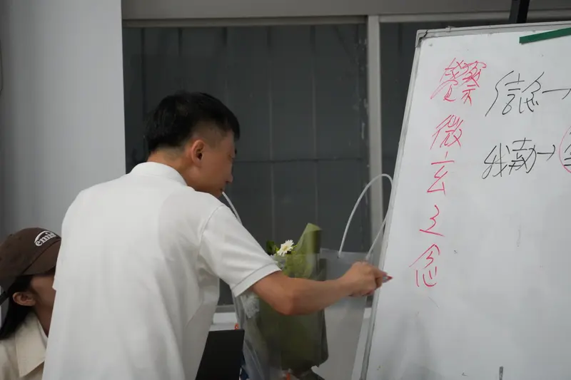 白板上寫滿字,講者站在旁邊