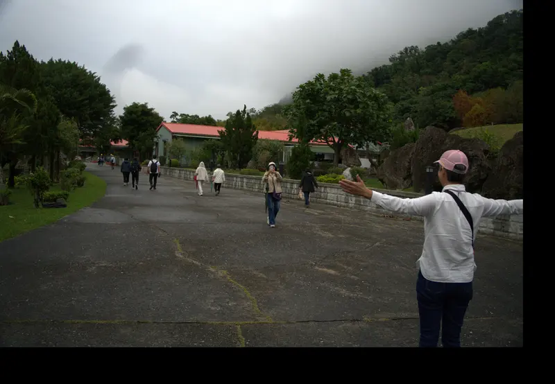 有人張開手臂站在步道上,遠處是夥伴